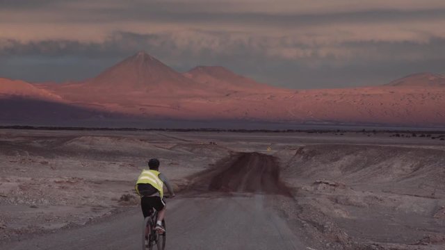 Bicycle traveler wearing a reflective vest
exploring the desert road in Atacama. 4k"