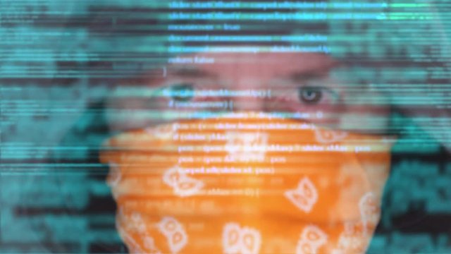 Cybersecurity, computer hacker with hoodie and obscured face, computer code overlaying footage