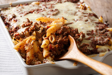 Million Dollar penne pasta with cheese and beef, close-up in a baking dish. Horizontal