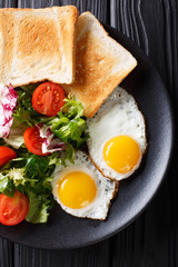 healthy breakfast of fried eggs with fresh vegetable salad and toast close-up. vertical top view