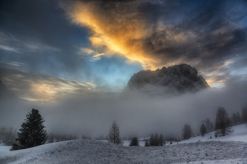 Sunset over the mountains and misty hills in winter season