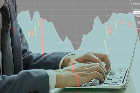 Double Exprosure of Business Man Typing Keyboard Laptop Hand with the Technical Graph for trading stock. Researching Process Global Strategy and Analyze market stock equity in blurred background.