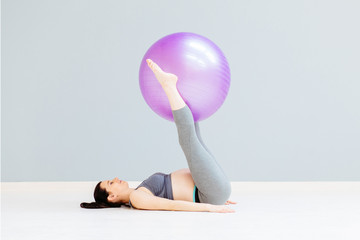 Fototapeta na wymiar Seria photo of a pregnant fitness woman doing exercises with fitball while lying on the floor indoor. Working out and fitness, pregnancy concept.