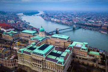 Obraz premium Budapest, Hungary - Aerial drone skyline view of Buda Castle Royal Palace with Szechenyi Chain Bridge and Parliament of Hungary on a cloudy winter day
