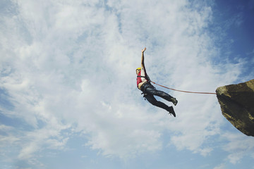 A man jumps into a canyon from a cliff.