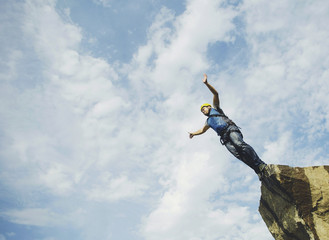 A man jumps into a canyon from a cliff.