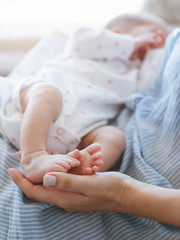mother holds the legs of her newborn baby. family values. love and tenderness.