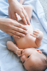 mother does a body massage to a newborn baby. mother's care. healthy lifestyle.