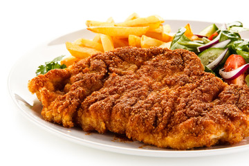 Fried pork chop, French fries and vegetables