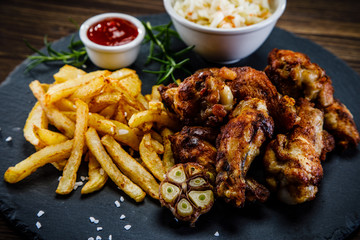 Kentucky wings with French fries wooden background
