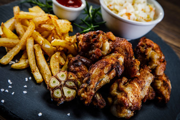 Kentucky wings with French fries wooden background