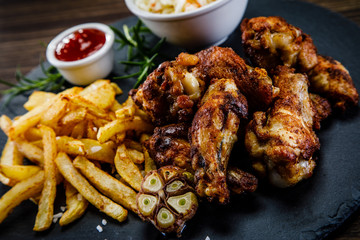 Kentucky wings with French fries wooden background