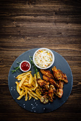 Kentucky wings with French fries wooden background