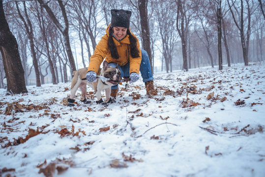 woman playing with french bulldog