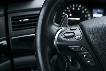 Plakat Media control buttons on the steering wheel in black perforated leather interior with computer monitor. Modern car interior details