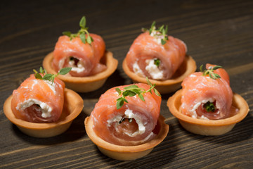Rolls of red fish with a delicate filling on tartlets