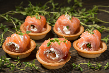 Rolls of red fish with a delicate filling on tartlets