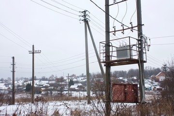 electrical distribution transformer on concrete pillars   in  the rural area in winter