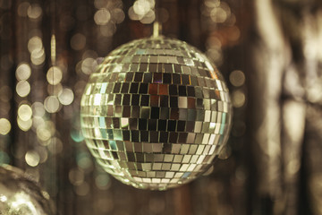 close-up shot of silver disco ball with garland on black background