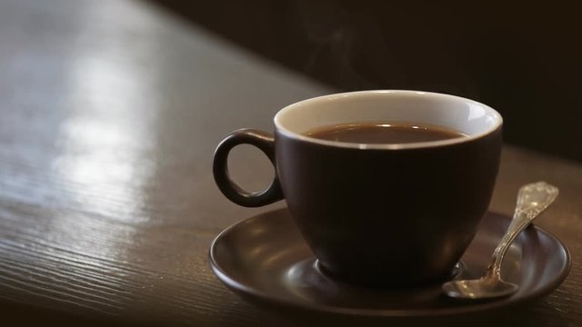 Steam from a cup with a hot coffee .  