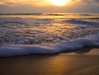Waves on the shore of a beach at sunrise