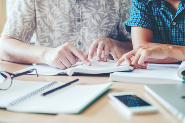 High school or college students studying and reading together in library