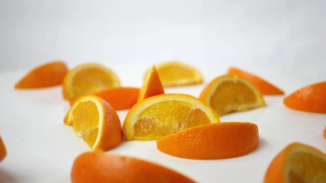 Sliced Orange wedges spinning over white background