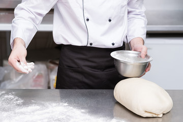 Obraz na płótnie Canvas Professional cook preparing dough for bread baking. Skillfull hands to make tasty foods
