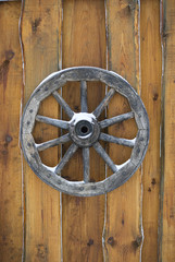 Old wooden wagon wheel hanging on the wall