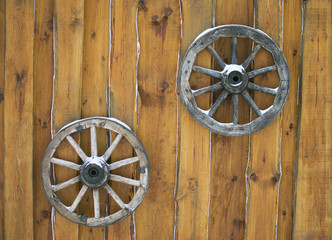 Two vintage wooden wagon wheel hanging on the wall