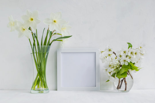 Mockup with a white frame and white daffodils in a vase