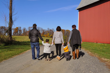 Family Walking Together Holding Hands by a Barn