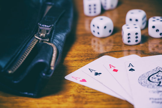 Gambling in casino. Poker cards, dice and leather jacket on a wooden table. Gambling concept