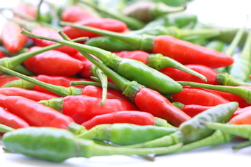 Close up group of green and red chillies on white background