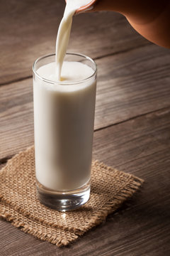 jug of milk with an old country table, a white drink is poured into a glass
