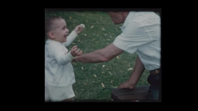 1961 Cute little shares food with playful grandfather