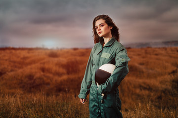 portrait of young beautiful girl pilot in the sunset field - obrazy, fototapety, plakaty