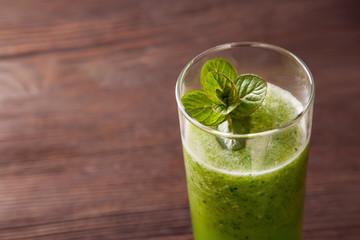 Green smoothie with spirulina on wood background