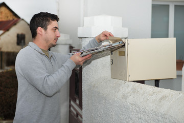 Man putting newspaper from the mailbox