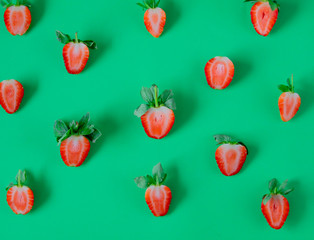 Strawberries isolated on green background.
