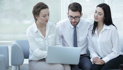 business team discussing information with laptop in office
