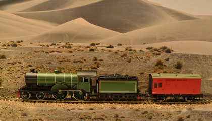 A Model of a 4-4-0 steam locomotive placed on a scenic background.