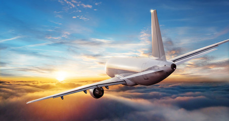 Fototapeta premium Odrzutowiec samolotu komercyjnego latające nad chmurami w pięknym świetle słońca.