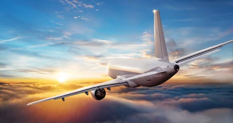 Abwaschbare Fototapete Flugzeug Kommerzielle Flugzeugjetliner, der über Wolken im schönen Sonnenunterganglicht fliegt.