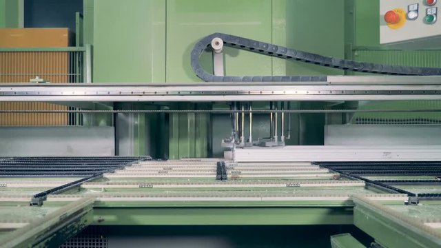 A robotic manipulator controls PVC window frame production.  