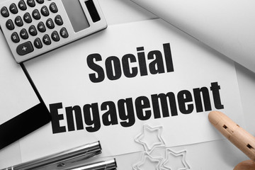 Sheet of paper with text SOCIAL ENGAGEMENT on office table