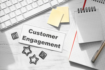 Sheet of paper with text CUSTOMER ENGAGEMENT on office table