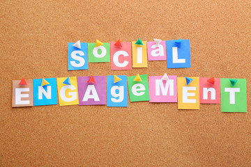 Text SOCIAL ENGAGEMENT made of paper letters on cork background