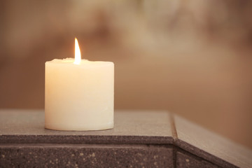 Burning candle against blurred background outdoors