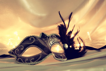 Image of elegant venetian mask over gold silk background. © tomertu